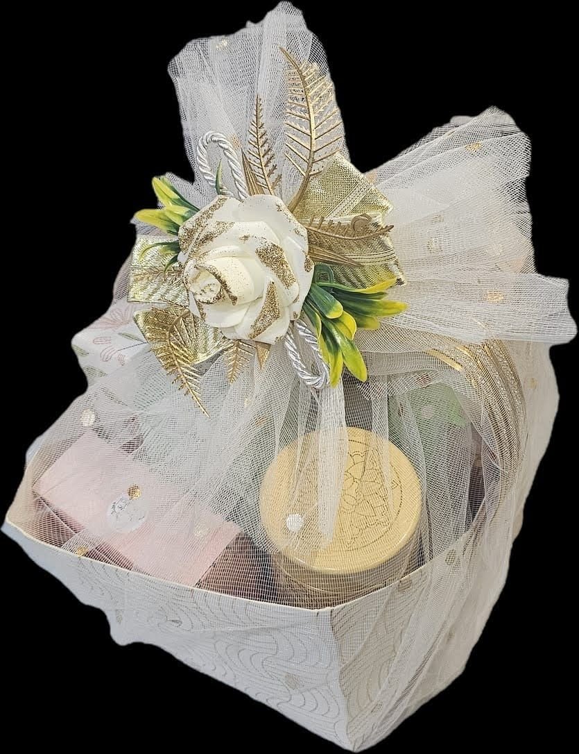 A gift hamper wrapped in ivory tulle and finished with a gold ribbon rose
