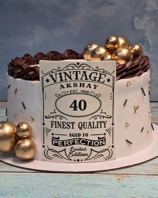 A white and chocolate milestone cake dressed with gold spheres