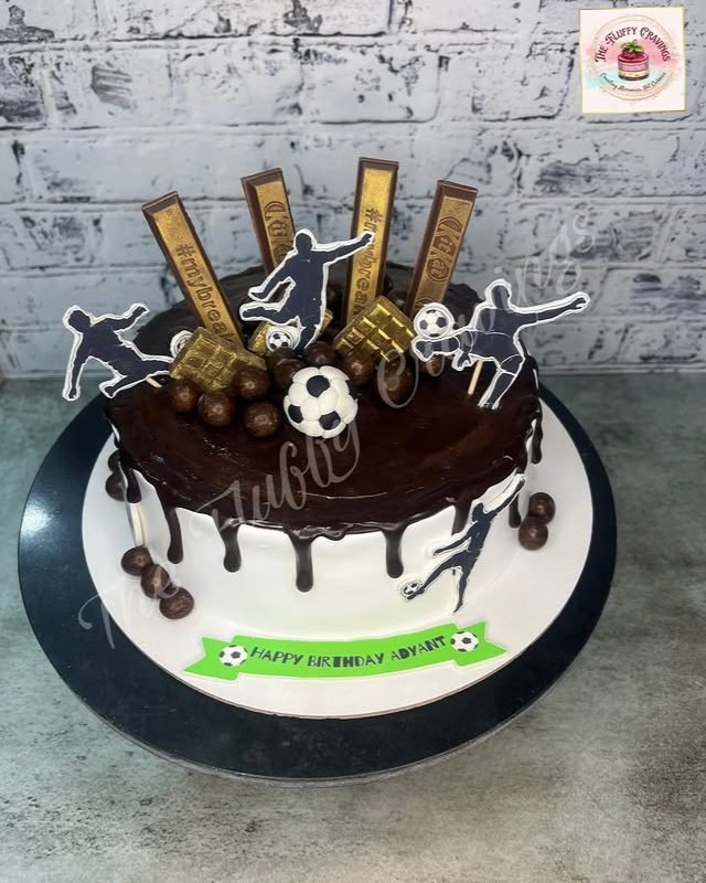 A chocolate drip cake topped with football figures and chocolate bars
