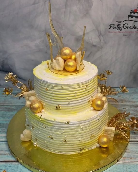 A two-tier ivory and gold ombre cake finished with hand-pulled sugar shards